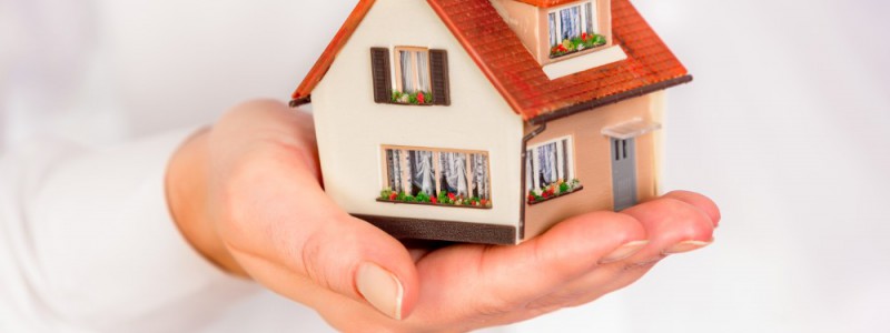 maison miniature posée sur une main
