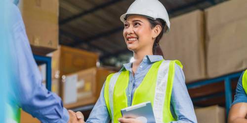 femme entrepreneure dans son entrepôt de logistique serrant la main du nouveau propriétaire du local commercial