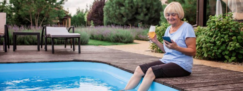 jardin avec piscine et personne retraitee les pieds dans l'eau