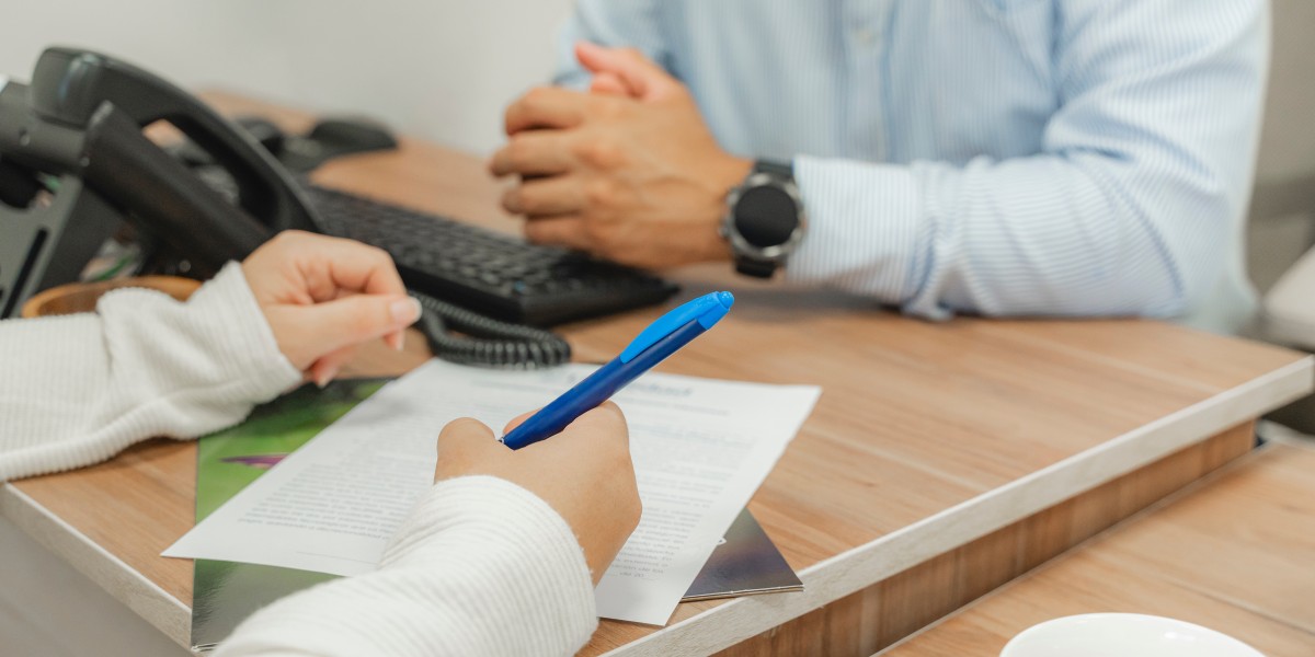 Gros plan sur une personne signant un contrat de prévoyance lors d'un entretien avec un conseiller pour souscrire une assurance décès.