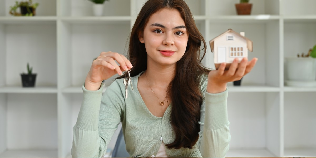 Une jeune femme souriante tenant les clés de son nouveau domicile et une maquette de maison, illustrant la sérénité apportée par une assurance emprunteur optimale.