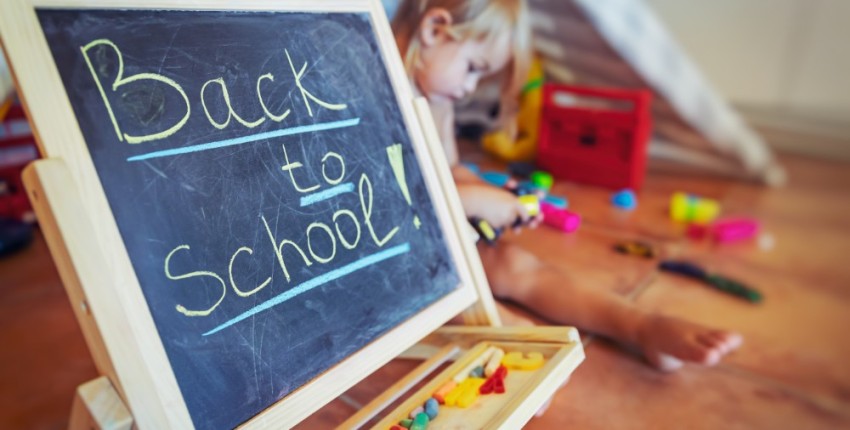 Back to school écrit sur un tableau noir avec un enfant derrière