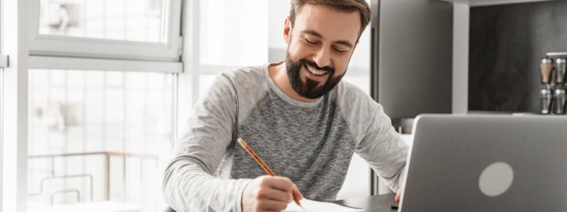 Jeune homme devant son ordinateur portable calculant sa capacité d'emprunt