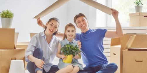 Un père, une mère et leur fille prêts à emménager dans leur nouvelle maison.