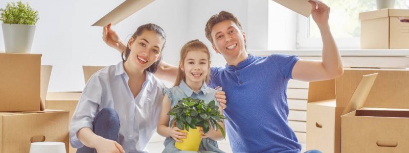 Un père, une mère et leur fille prêts à emménager dans leur nouvelle maison.