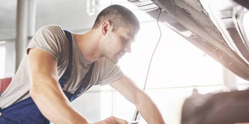 Mécanicien en train de réparer le moteur d'une voiture