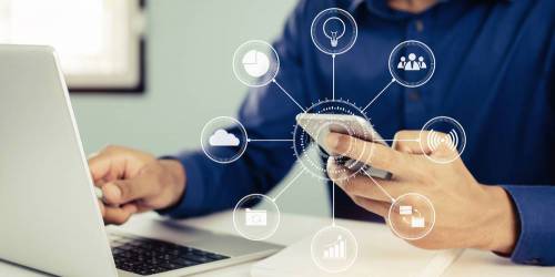 Homme devant son ordinateur et son téléphone choisissant un FAI avec un comaprateur