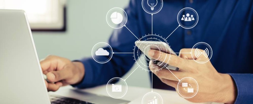 Homme devant son ordinateur et son téléphone choisissant un FAI avec un comaprateur