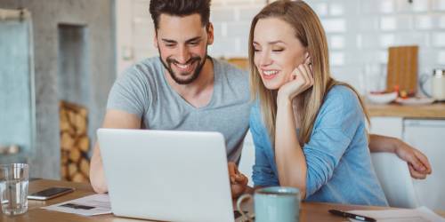 Un couple effectue un rachat de prêts personnels devant leur ordinateur