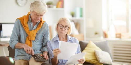 Couple senior vérifiant le calcul de la taxe d'habitation