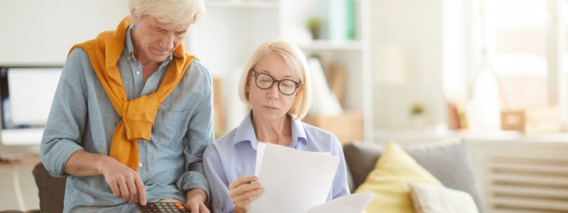 Couple senior vérifiant le calcul de la taxe d'habitation