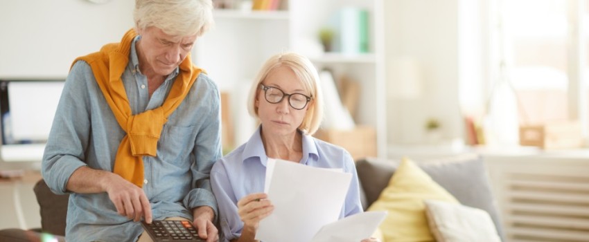 Couple senior vérifiant le calcul de la taxe d'habitation