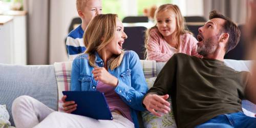 parents dans le canapé et leurs deux enfants derrière eux