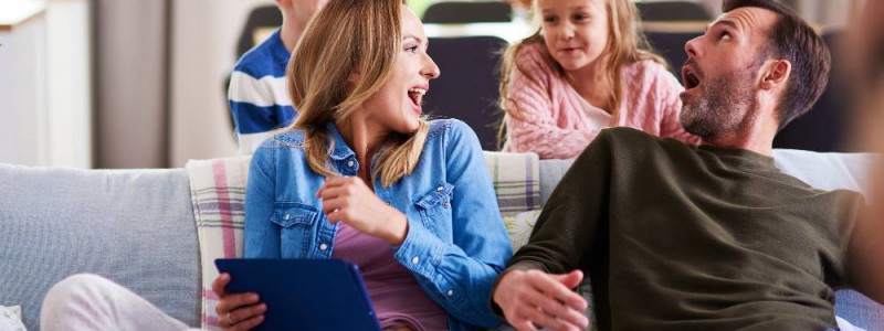 parents dans le canapé et leurs deux enfants derrière eux