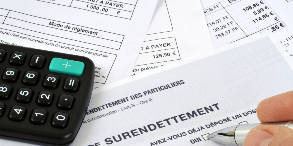 Main cochant une case sur un formulaire de déclaration de surendettement, entourée d'une calculatrice et de factures de particuliers.