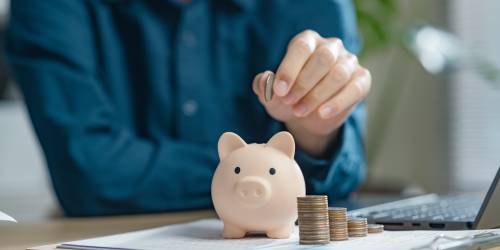 homme mettant une pièce dans une tirelire