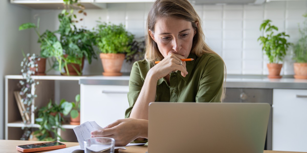 Étude de cas d'un rachat de crédit locataire : une personne gère son budget et ses mensualités depuis sa cuisine.
