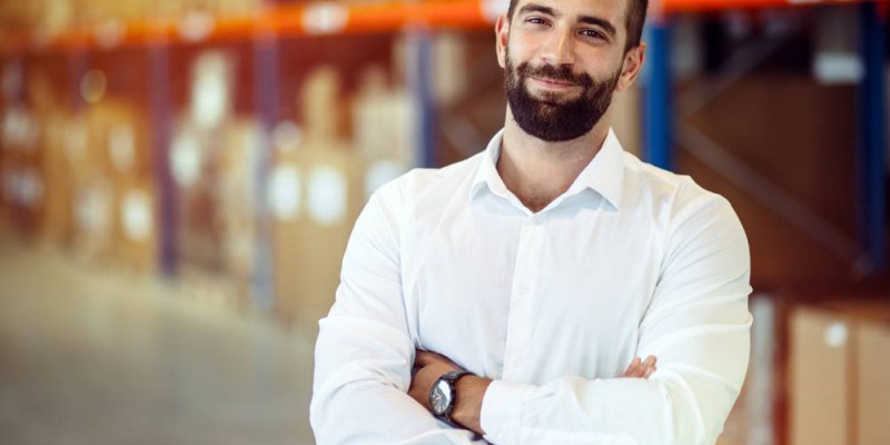 Entrepreneur bras croisés confiant devant son stock de marchandise
