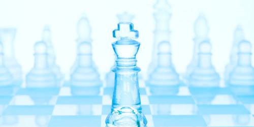 Jeu d'échec en verre de teinte bleuté. Le roi est placé en avant plan.