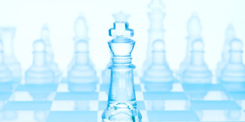 Jeu d'échec en verre de teinte bleuté. Le roi est placé en avant plan.