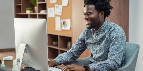 homme assit devant ordinateur regarde les taux de rachat de crédits à la consommation
