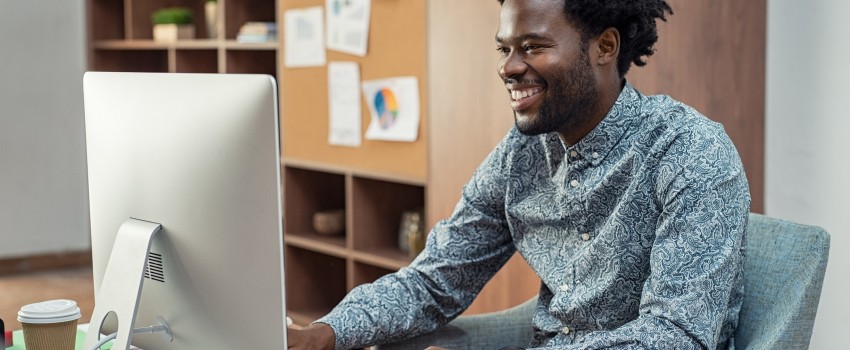homme assit devant ordinateur regarde les taux de rachat de crédits à la consommation