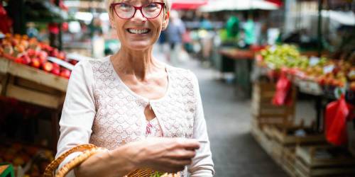 femme au marché heureuse d'avoir trouvé le meilleur rachat de crédit