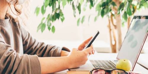 jeune femme cherchant la meilleure banque en ligne sur son ordinateur et son portable