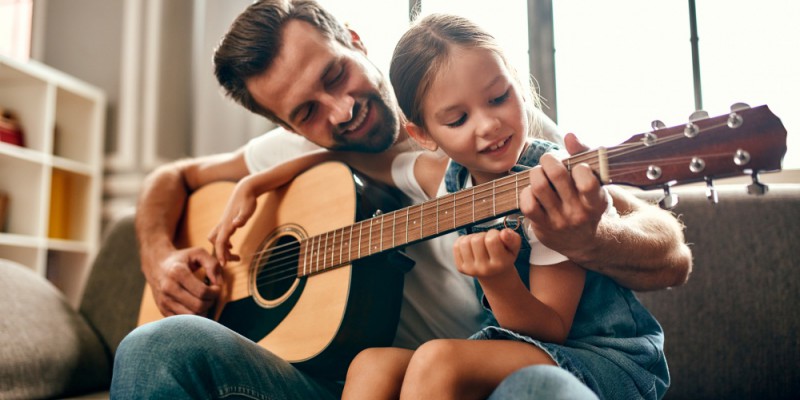 père célibataire qui fait de la guitare avec sa fille