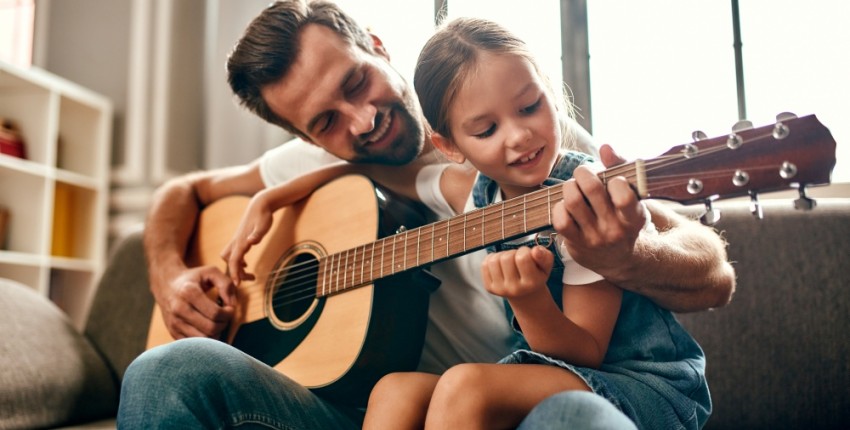 père célibataire qui fait de la guitare avec sa fille