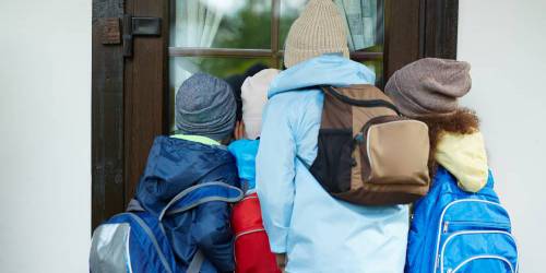 Enfants prêts pour l'école regardant par la fenêtre