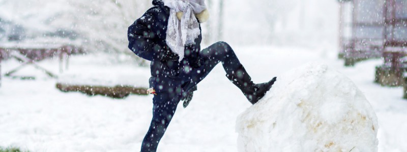 enfant fier devant son énorme boule de neige
