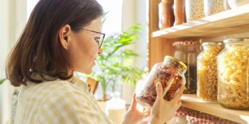 femme économe dans son placard à bocaux
