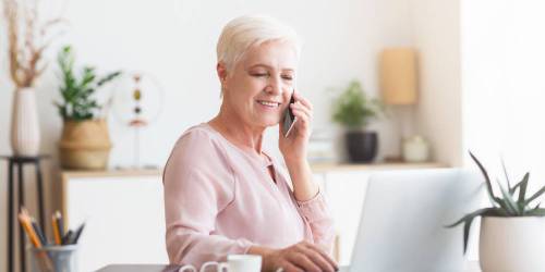 Femme d'âge mûr faisant des recherches sur son ordinateur pour financer ses travaux de transition énergétique