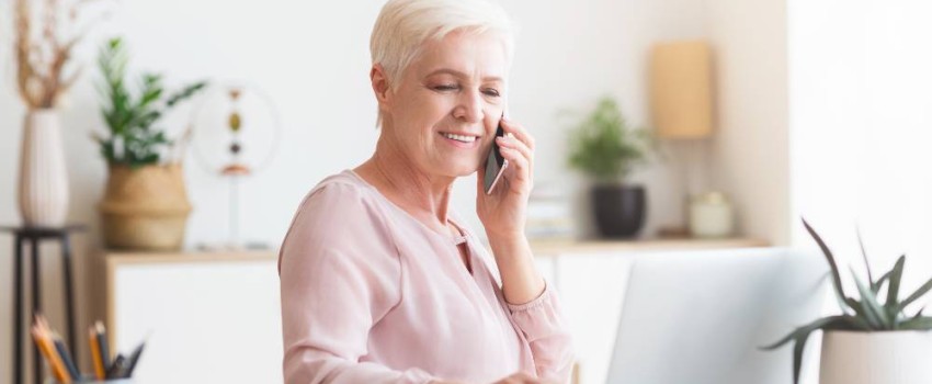 Femme d'âge mûr faisant des recherches sur son ordinateur pour financer ses travaux de transition énergétique