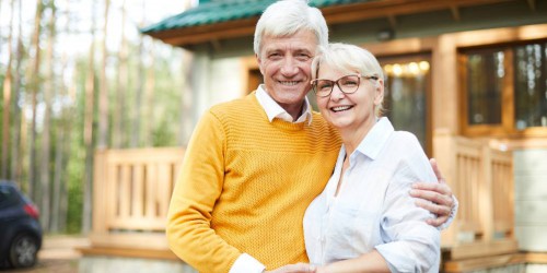 couple de retraites devant leur maison
