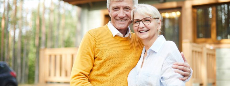 couple de retraites devant leur maison