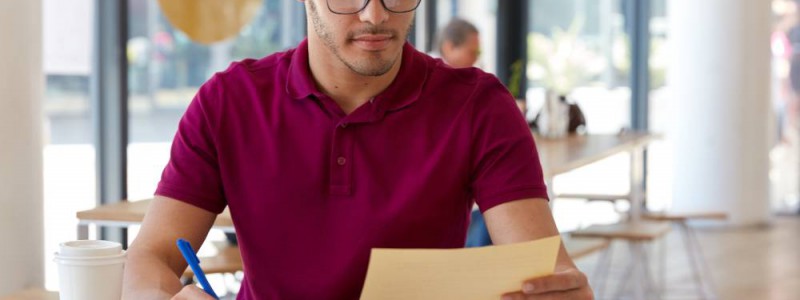 jeune homme à lunettes calculant ses indemnités de remboursement anticipé