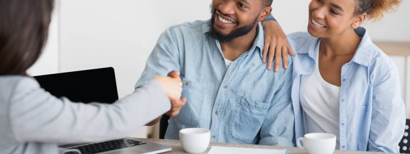 couple serrant la main de la courtière en assurance