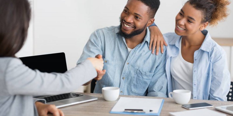 couple serrant la main de la courtière en assurance