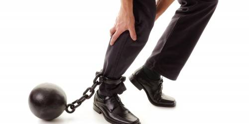 un entrepreneur avec un boulet de prisonnier accroché à sa cheville