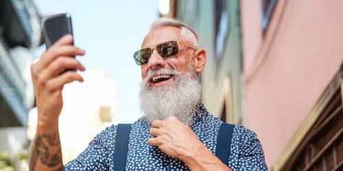 Homme âgé et barbu regardant son smartphone