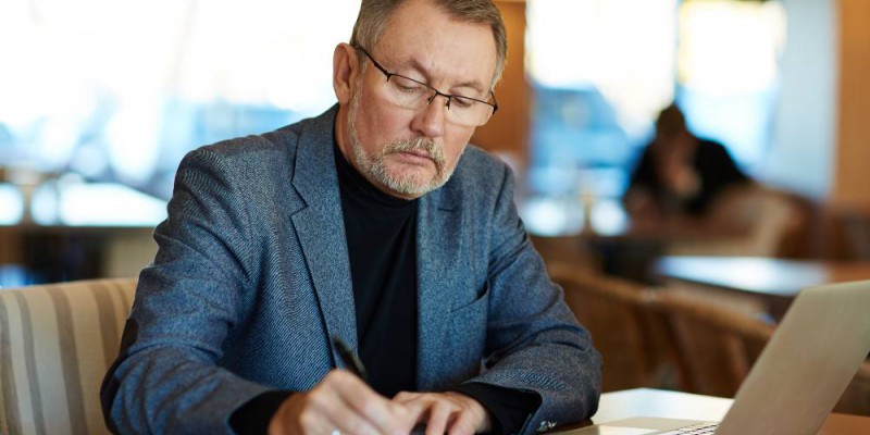 chef d'entreprise qui prend des notes sur le prêt de trésorerie hypothécaire avec Partners Finances.