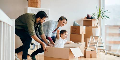 famille en train d'emménager et de jouer avec les cartons