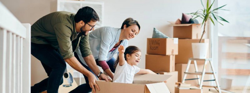 famille en train d'emménager et de jouer avec les cartons