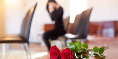 Roses rouges posées sur meuble en bois dans un funérarium.