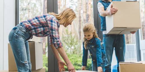 famille, parents et leurs fille, transportant leurs cartons de déménagement