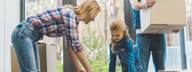 famille, parents et leurs fille, transportant leurs cartons de déménagement