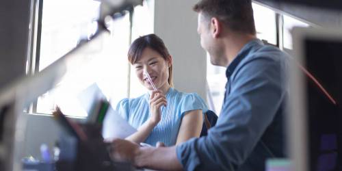 Un homme et une femme, collaborateurs, souriants