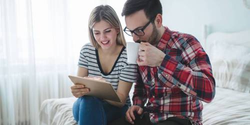 couple se renseignant sur l'estimation du bien immobilier à acquérir sur une tablette